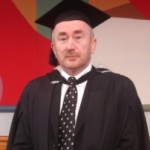 David Armstrong in gown, mortar board